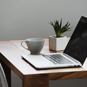 A laptop and cup on a table